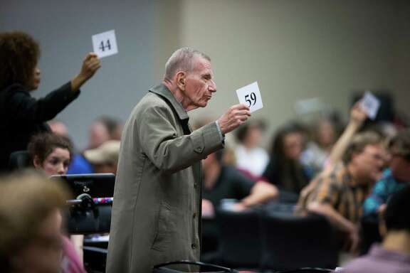 Jim Sel, center, and others display their numbers to officials from the U.S. Department of Education and the Texas Education Agency in a bid to extend Monday's "listening session" on special education in Texas.