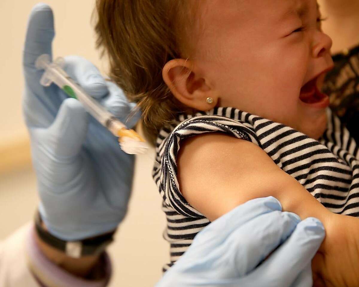 Daniela Chavarriaga holds her daughter, Emma Chavarriaga, as pediatrician Jose Rosa-Olivares, M.D. administers a measles vaccination during a visit to the Miami Children's Hospital on June 02, 2014 in Miami, Florida.