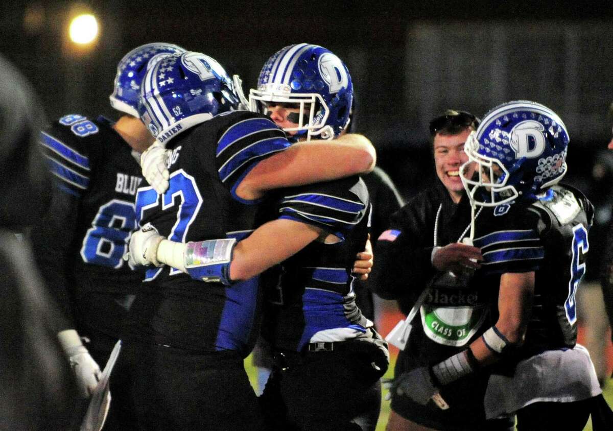 Darien's Brian Keating, left, and teammate Riley Stewart embrace as they celebrate the team's win over Ridgefield in Class LL Championship football action in West Haven, Conn. on Saturday Dec. 10, 2016. Darien defeated Ridgefield 28-7.