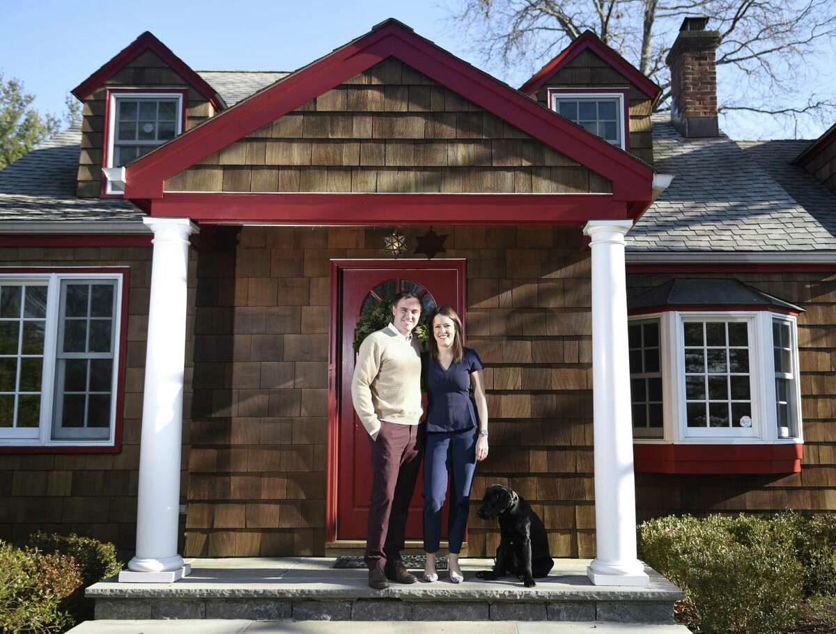 Millennial home buyers Ryan Particelli and Jennifer Bayard Particelli pose with their dog, Chevy, in front of their home on Mead Avenue in the Cos Cob section of Greenwich, Conn. Wednesday, Dec. 14, 2016.