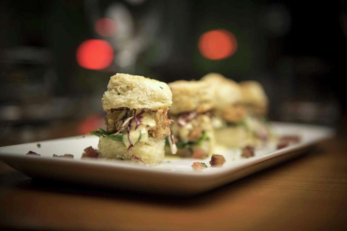 Oyster sliders with crispy fried Gulf oysters, candied bacon, buttermilk chive biscuits, spinach, brown butter hollandaise and chives from Bliss