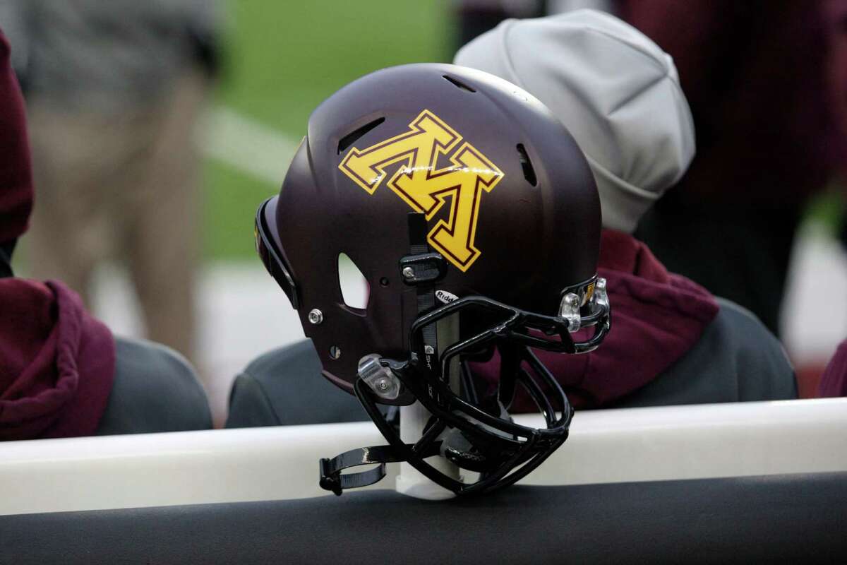 FILE - In this Nov. 24, 2012, file photo, a Minnesota helmet hangs on a sideline heater during an NCAA college football game against Michigan State, in Minneapolis. Ten Minnesota football players were suspended this week following a fresh investigation into an alleged sexual assault at an off-campus apartment in September, the father of a player and an attorney for several players said Wednesday, Dec. 14, 2016.