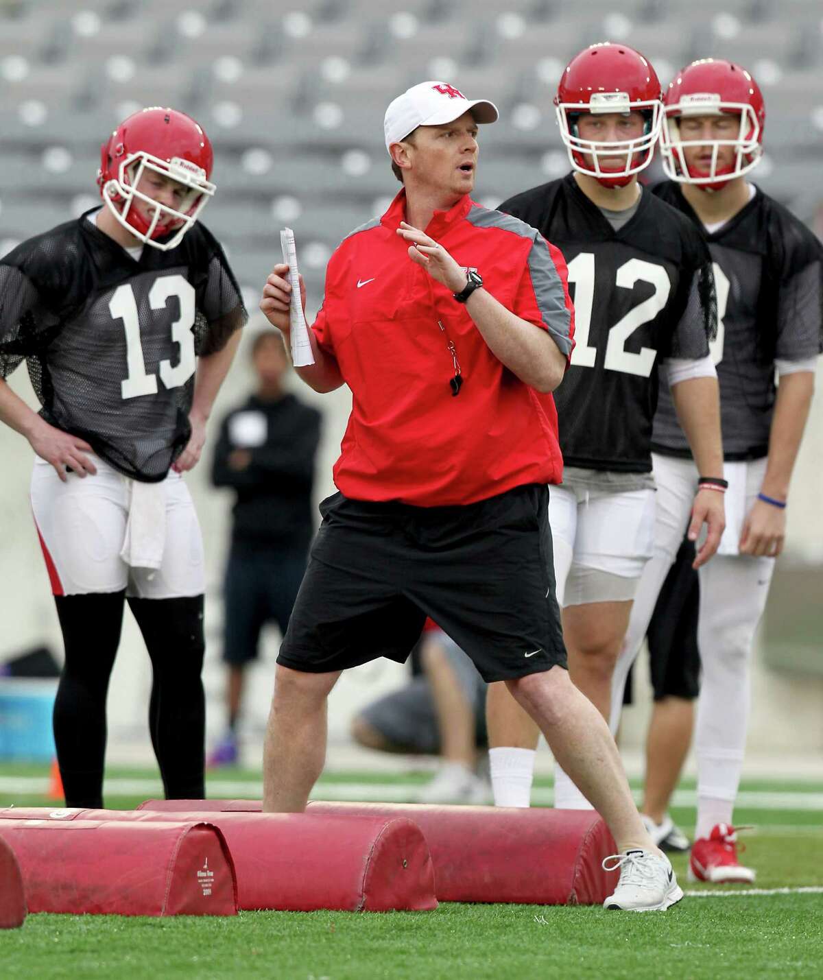 In this March 10, 2015 photo, Houston quarterbacks listen to quarterback coach Major Applewhite demonstrate a foot drill during spring NCAA college football practice in Houston. Applewhite was hired to replace Tom Herman as coach at Houston on Friday, Dec. 9, 2016. (Thomas B. Shea/Houston Chronicle via AP)