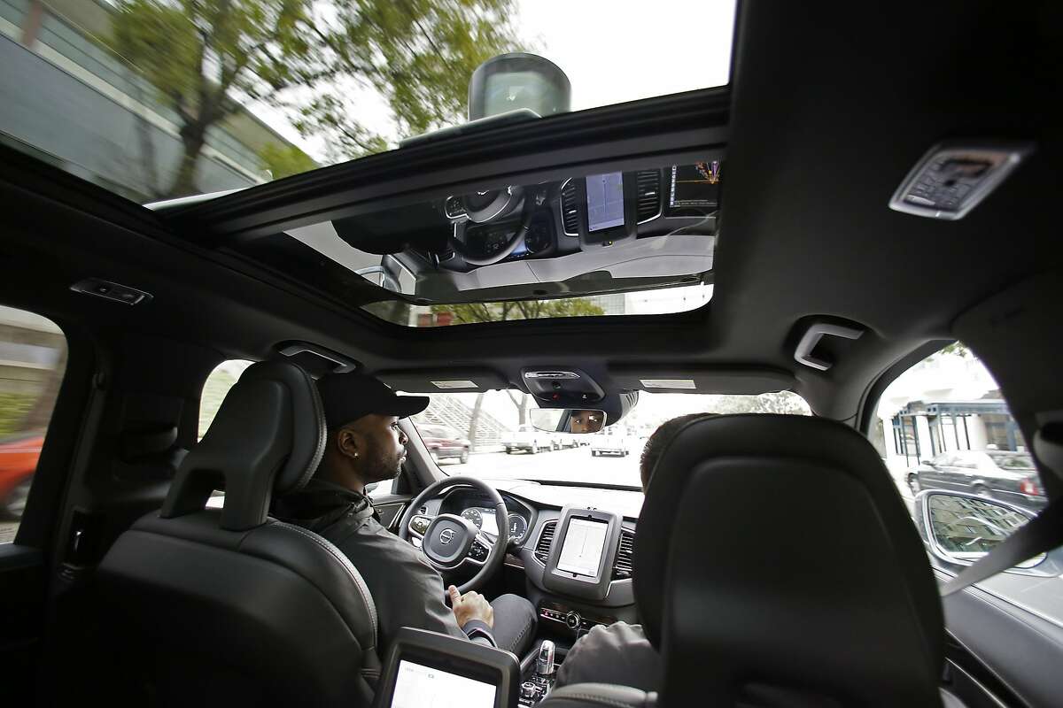 In this file photo, Devin Greene sits in the front seat of an Uber driverless car during a test drive in San Francisco. Uber is riding its self-driving cars into a legal showdown with California regulators. The ride-hailing company is refusing to obey demands by the state's Department of Motor Vehicles that it stop picking up San Francisco passengers in specially equipped Volvo SUVs. Hours after Uber launched the self-driving service Wednesday, Dec. 14, the DMV warned it was illegal because the cars did not have a special permit. (AP Photo/Eric Risberg)