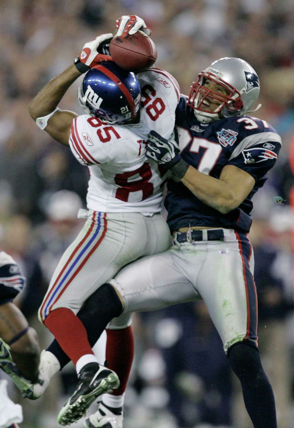 In this Feb. 3, 2008, file photo, the New York Giants receiver David Tyree (85) catches a 32-yard pass in the clutches of New England Patriots safety Rodney Harrison (37) during the fourth quarter of the Super Bowl XLII football game at the University of Phoenix Stadium on Sunday, Feb. 3, 2008 in Glendale, Ariz. The New England Patriots are back in the Super Bowl against the New York Giants, the team that ruined their perfect season in that game four years ago. They advanced with one of Tom Brady's worst games of the season and unheralded Sterling Moore's best. (AP Photo/Gene Puskar)