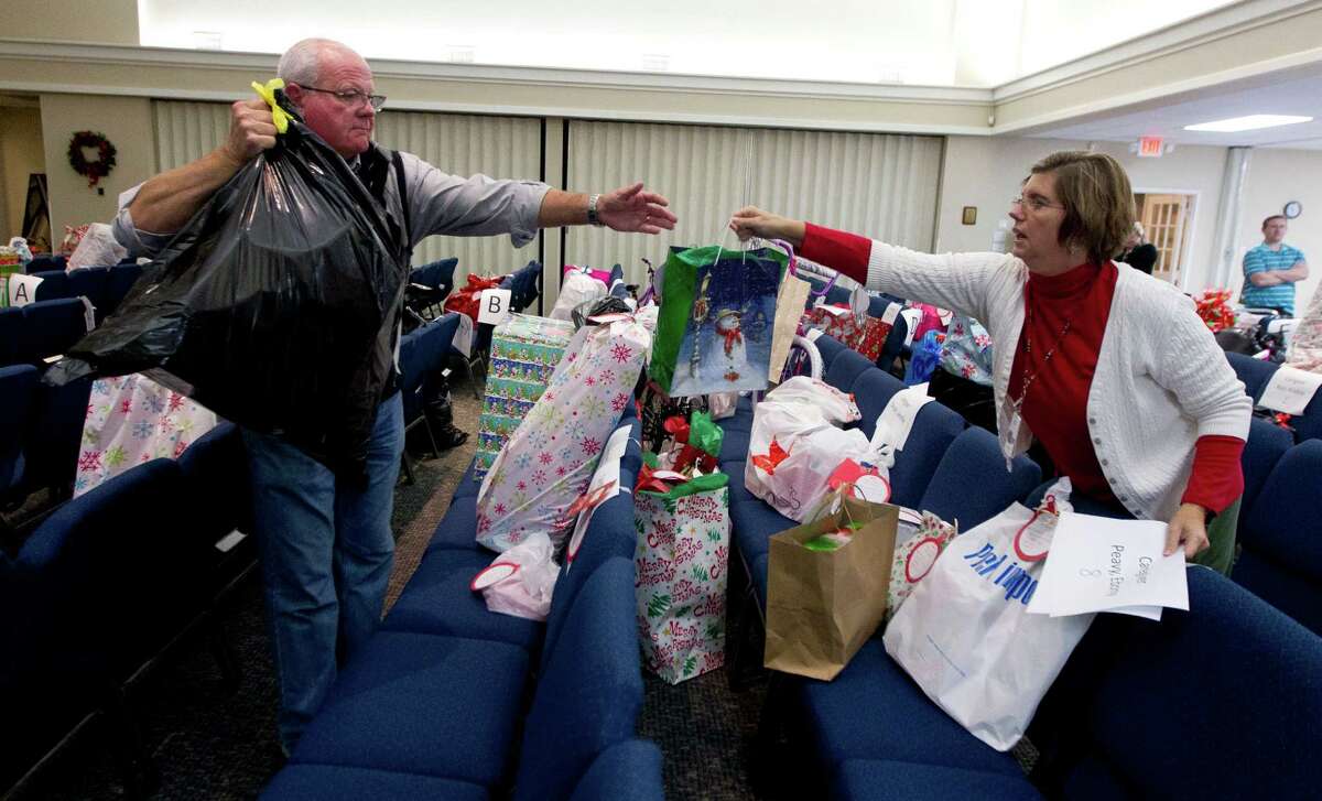 Cindy Perkins, right, hands Senior Pastor Jay Gross presents for foster children at West Conroe Baptist Church Thursday, Dec. 14, 2016, in Conroe. The church partnered with Orphan Care Solutions to provide Christmas gifts to 187 children in foster care.