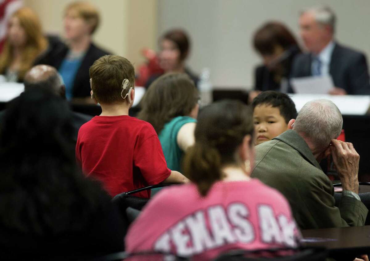 A child listens to representatives from the U.S. Department of Education's Office of Special Education and Rehabilitative Services (OSERS) and the Texas Education Agency (TEA) as they make initial remarks, Monday, Dec. 12, 2016, in Houston. The hearing will provide parents and school officials the opportunity to comment on the timely identification and evaluation of students with disabilities. ( Marie D. De Jesus / Houston Chronicle )