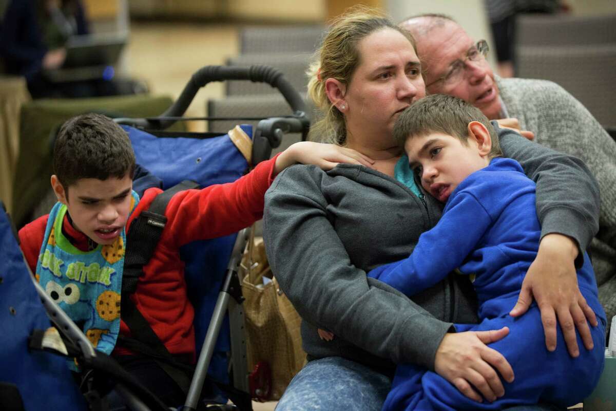 Yajaira Hernandez comforts her sons Edwin, left, and Harry while she listens at the Austin session.
