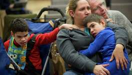 Yajaira Hernandez comforts her sons Edwin, left, and Harry while she listens at the Austin session.