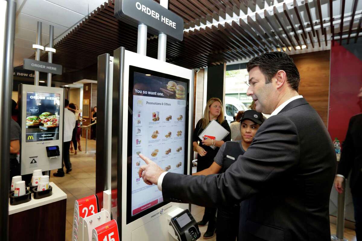 McDonald's CEO Steve Easterbrook demonstrates an order kiosk, with cashier Esmirna DeLeon, during a presentation at a McDonald's restaurant in New York's Tribeca neighborhood last month. Restaurant chains including McDonald's and Olive Garden are rolling out options like ordering kiosks.