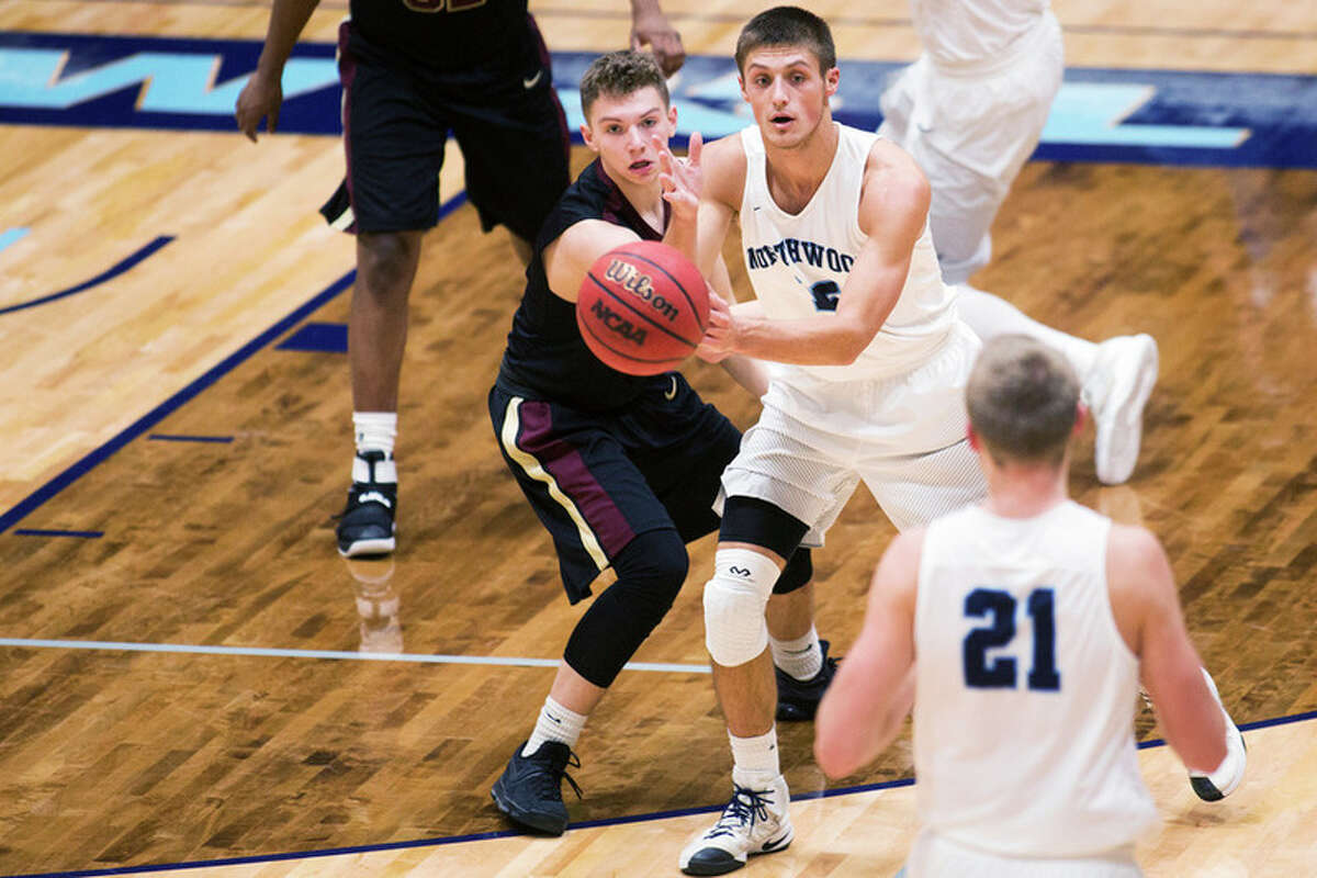 THEOPHIL SYSLO | For the Daily News Northwood's Brad Schaub passes the ball while being defended by Walsh's Will Parker in a game at Northwood University on Thursday.