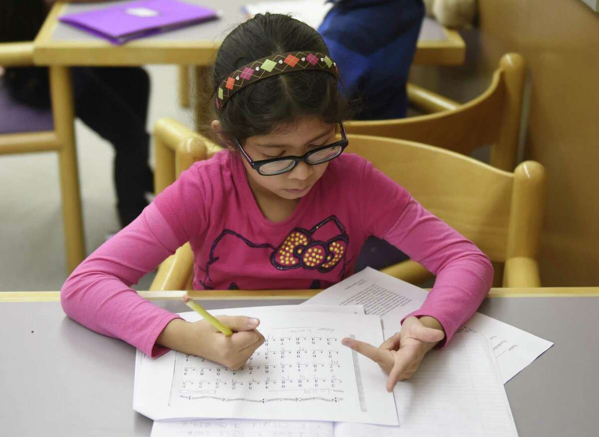 Lolita Veas works on her math homework at an after-school program at the Yerwood Center in Stamford.