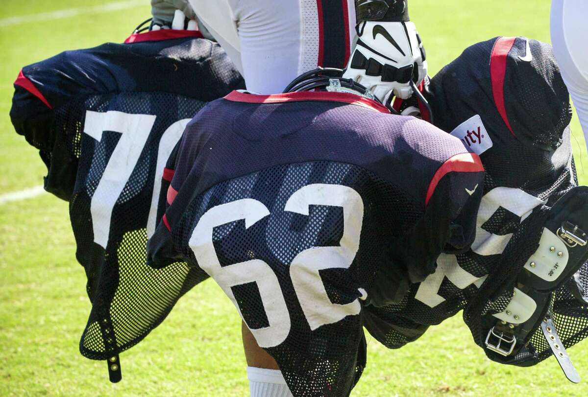 Houston Texans rookie offensive lineman Chad Slade carries his, Duane Brown's and James Ferentz' pads off the field at the end of practice during Texans training camp at the Methodist Training Center Tuesday, Aug. 11, 2015, in Houston. ( Brett Coomer / Houston Chronicle )