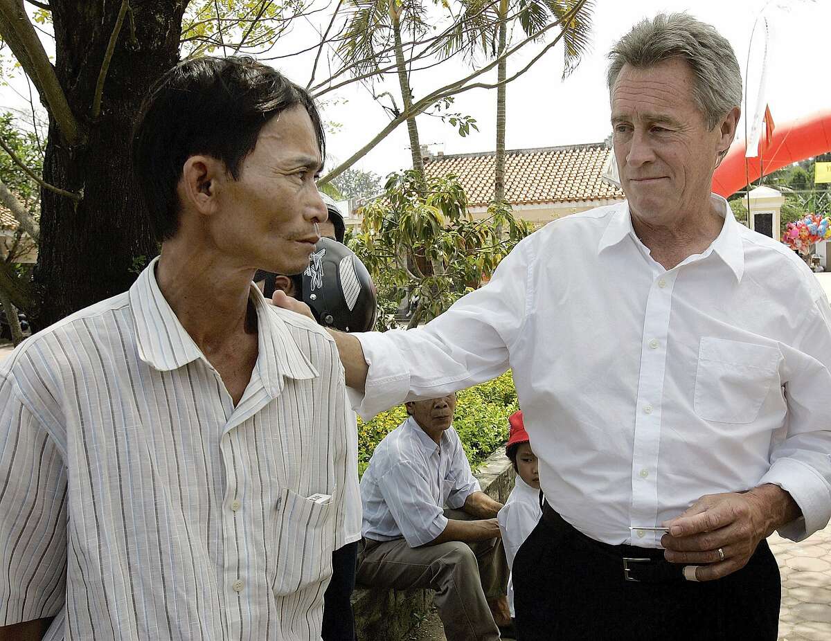 FILE - In this Saturday, March 15, 2008 file photo, My Lai Massacre survivor Do Ba, 48, left, stands with former U.S. Army officer Lawrence Colburn, 58, right, who rescued him during the March 16, 1968 My Lai massacre, during the 40th anniversary of the incident in My Lai, Quang Ngai Province, Vietnam. Colburn, the helicopter gunner who helped end the slaughter of hundreds of unarmed Vietnamese villagers by American troops during the Vietnam War, died on Tuesday, Dec. 13, 2016. He was 67. (AP Photo/Chitose Suzuki)