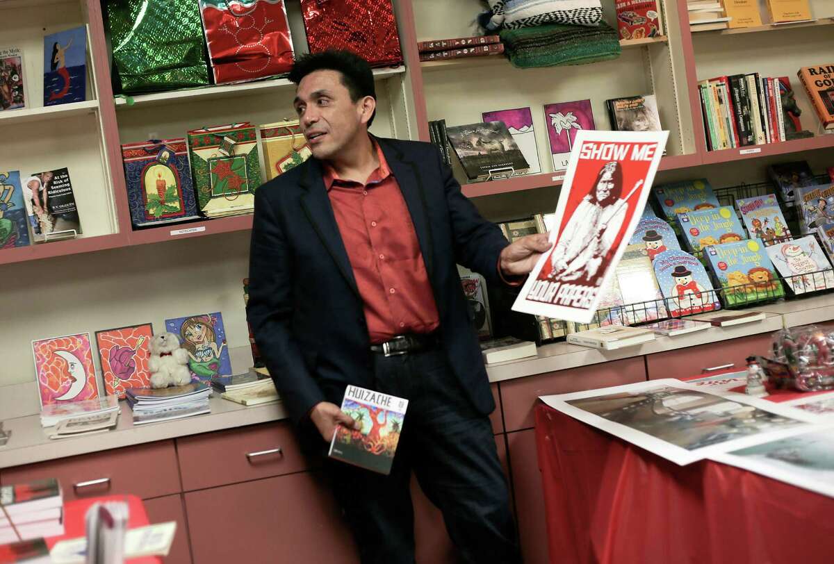 Tony Diaz shows some of the art and books that are for sale at the new store.