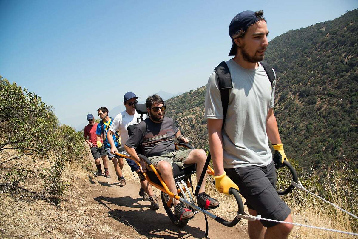 Javier Navarro, front, carries Alvaro Silberstein while trekking Sunday, Dec. 11, 2016 in Santiago, Chile. Alvaro Silberstein wants to expand the places disabled people can go in the world. This week, the 31-year-old graduate student hopes to become the first person in a wheelchair to trek in three wild regions of primeval Torres del Paine National Park in Chilean Patagonia