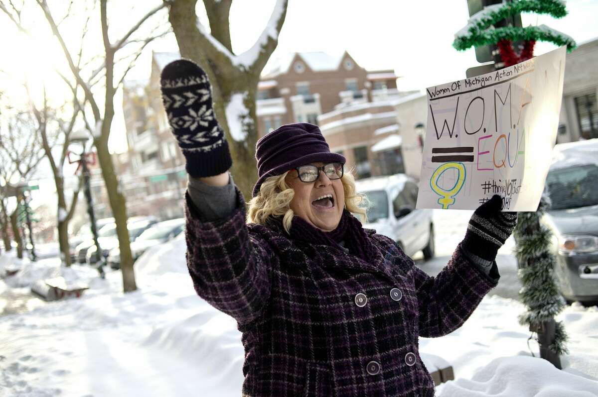 Organizer Jody Liebmann leads the group in a chant on Saturday in downtown Midland. More than 30 people met at the corner of Gordon and Main streets for a rally and march to celebrate the resistance of policy and intolerance based on fear and hate. The event was hosted by the Women of Michigan Action Network (W.O.M.A.N.), a local group for positive change and resistance formed in response to the election of Donald Trump. The group marched between Gordon and Ashman streets and chanted slogans including, "Show me what democracy looks like, this is what democracy looks like," and "Love not hate makes America great," to name a few. The group also sang, "America the Beautiful" and "This Land Is Your Land."