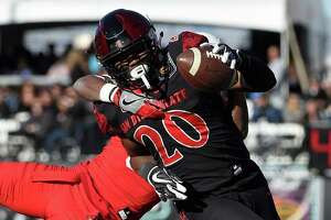 San Diego State running back Rashaad Penny (20) runs with the ball against Houston cornerback Howard Wilson (6) during the first half of the Las Vegas Bowl NCAA college football game on Saturday, Dec. 17, 2016, in Las Vegas. (AP Photo/David Becker)
