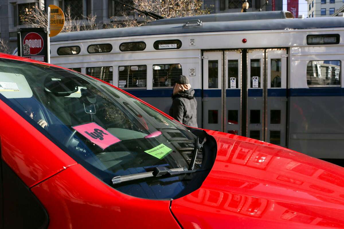 An Lyft car is seen next to a Muni stop on Market Street on Friday, December 17, 2016 in San Francisco, Calif.
