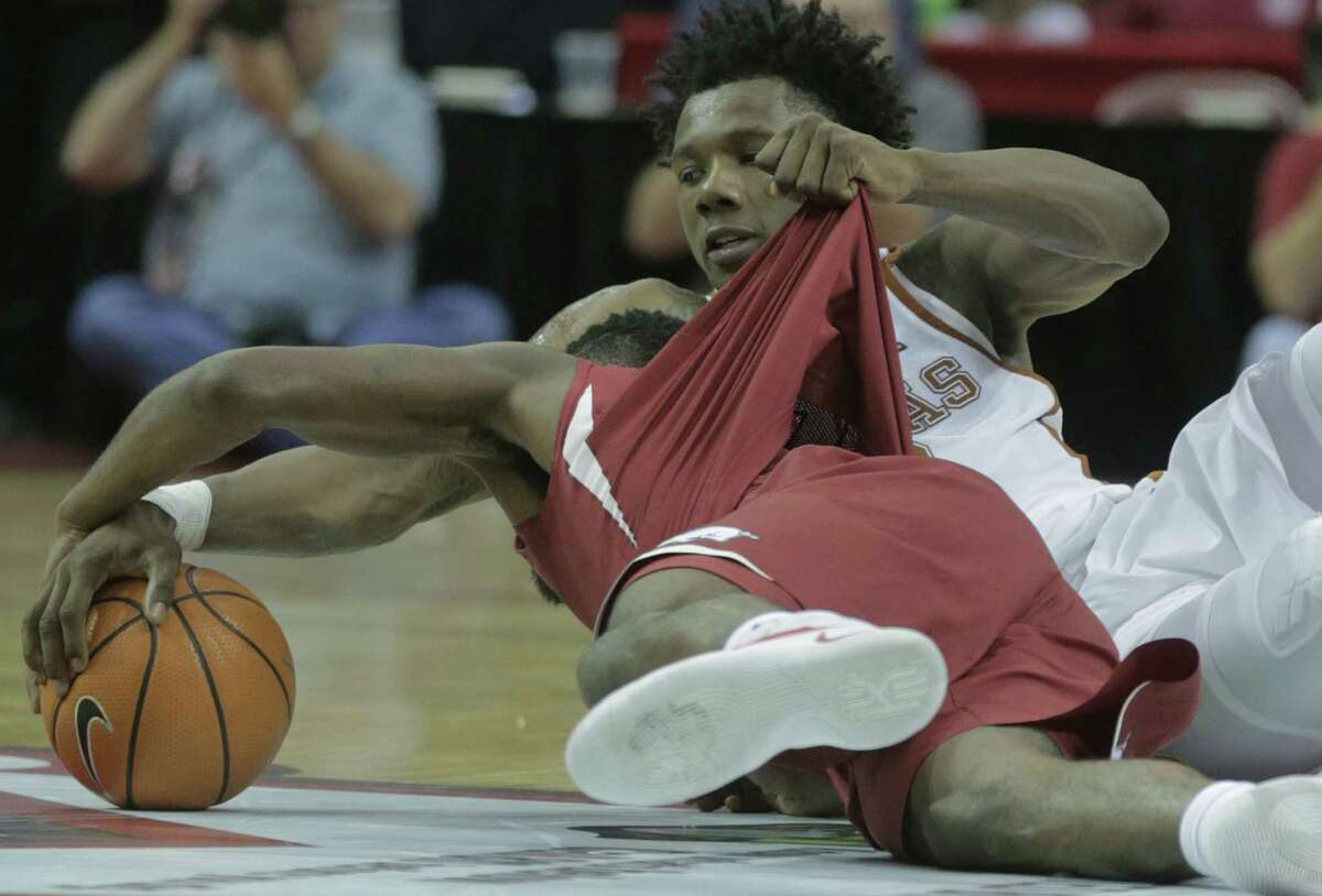 Texas' Tevin Mack, right, does what he has to as he battles for control of the ball with Arkansas' Daryl Macon during Saturday's game at Toyota Center.