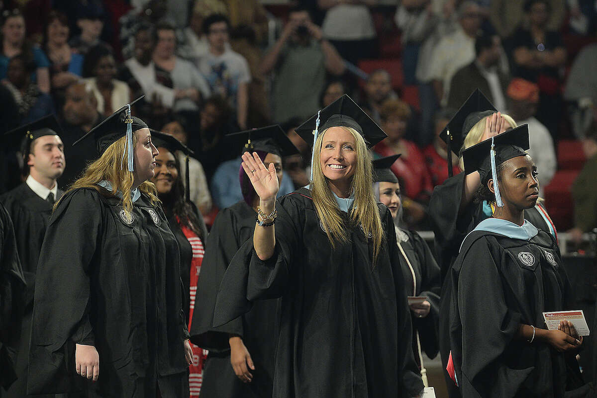 Fall graduates from Lamar University's Education and Human Development programs wave to family and friends as they make their way into the arena during Saturday's commencement ceremony at the Montagne Center. The program was one of two ceremonies held Saturday, with Fine Arts and Communication students receiving their diplomas earlier in the afternoon. Dr. James M. Simmons, who served as president of the university for 14 years, was the keynote speaker at the evening ceremony. Photo taken Saturday, December 17, 2016 Kim Brent/The Enterprise