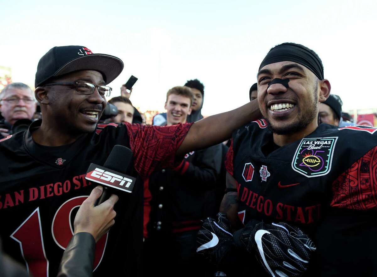 San Diego State running back Donnel Pumphrey Jr., right, is congratulated by his father Donnel Pumphrey Sr. after he was named the most valuable player in the Las Vegas Bowl NCAA college football game against Houston, Saturday, Dec. 17, 2016, in Las Vegas. (AP Photo/David Becker) ORG XMIT: NVDB108