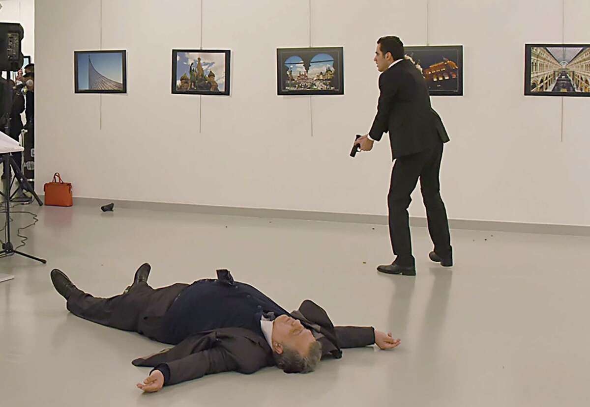 Andrey Karlov, Russia’s ambassador to Turkey, lies on the floor of an Ankara arts center after he was shot at an exhibition. He died, and the gunman (right) was killed by Turkish police. Video footage showed him shouting, “Don’t forget Aleppo, don’t forget Syria! … Only death can take me from here.”