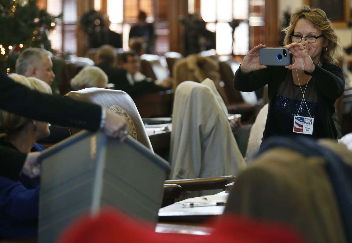A Texas Electoral College elector photographs a colleague casting a ballot in in Austin on Dec. 19, 2016. Federal lawsuits have been filed in four states, including Texas, that contest the winner-take-all method that states use to allocate their Electoral College votes.