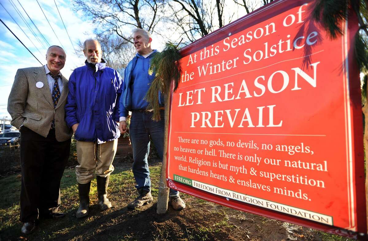 From left; John Levin, of Norwalk, Cary Shaw, of Norwalk, and Jerry Bloom, of Shelton, members of Humanists and Free Thinkers of Fairfield County, stand by the group's winter solstice sign on the Huntington Green in Shelton, Conn. on Monday, December 12, 2016. The group's original request to post the sign was denied by the town but then accepted after they initiated legal action.