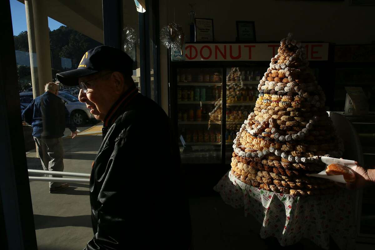 From left: Ed Raffo, Vern Alonzo and Robert Roach (carrying a jelly filled donut) head out of Donut Time on Tuesday, Dec. 20, 2016 in Pacifica, Calif. The longtime donut shop, located at 1235 Linda Mar Shopping Center, is set to lose its lease and close in January. Raffo and Alonzo, both of Pacifica, said they've regularly visited the shop for more than 25 years.