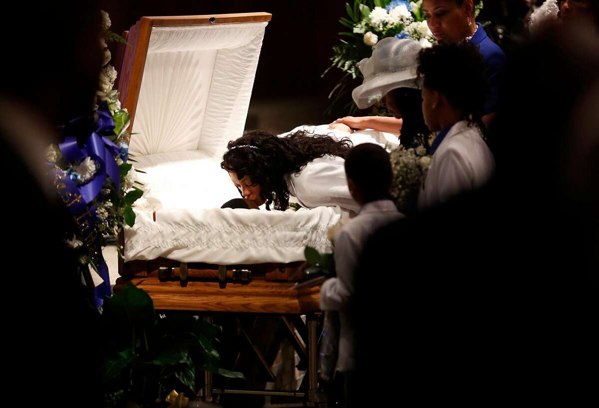 Audrey Hughes Cornish kisses her son Torian Hughes during his funeral at Shiloh Church in Oakland, California, on Monday, Jan. 11, 2016.
