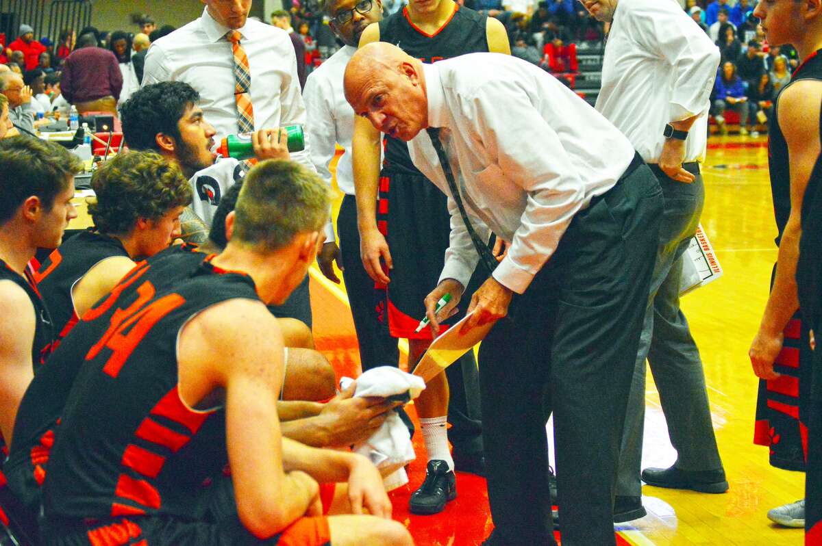 Edwardsville boys’ basketball coach Mike Waldo, right, talks to his team during a timeout in a regular season game against Belleville West at SIUE’s Vadalabene Center.