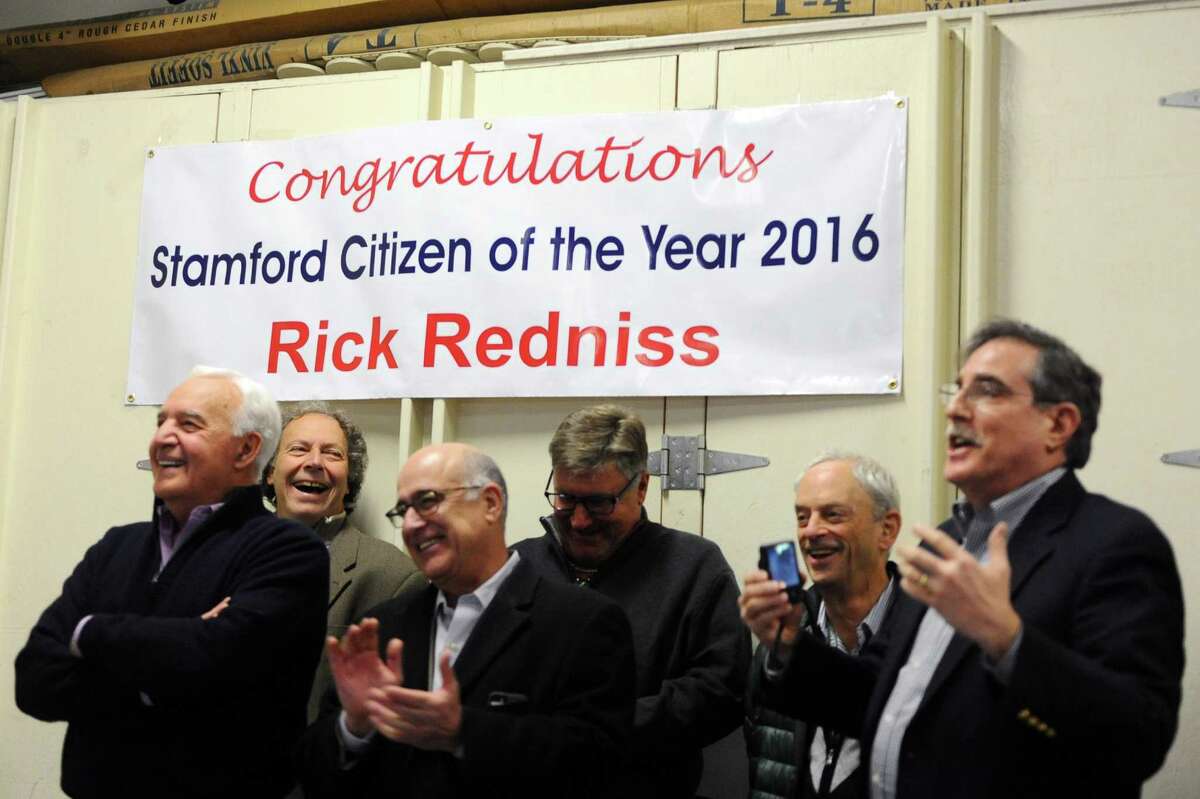 A crowd congratulates 2016 Stamford Citizen of the Year Rick Redniss during a surprise announcement in the garage behind his office on First St. in Stamford, Conn. on Wednesday, Dec. 21, 2016.