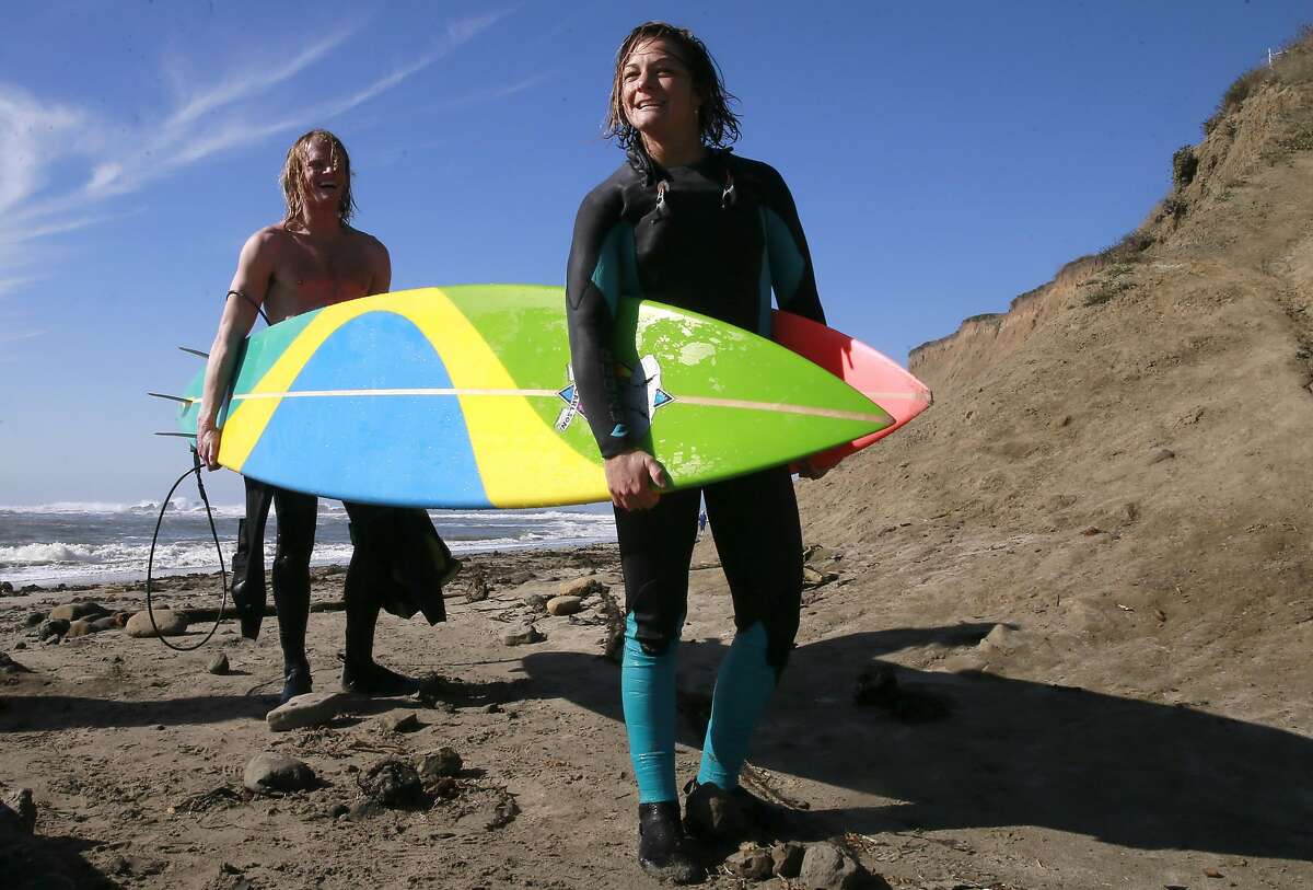 Dr. Joseph Hardeman (left) and Bianca Valenti carry their boards to the car after surfing at Mavericks in Half Moon Bay.