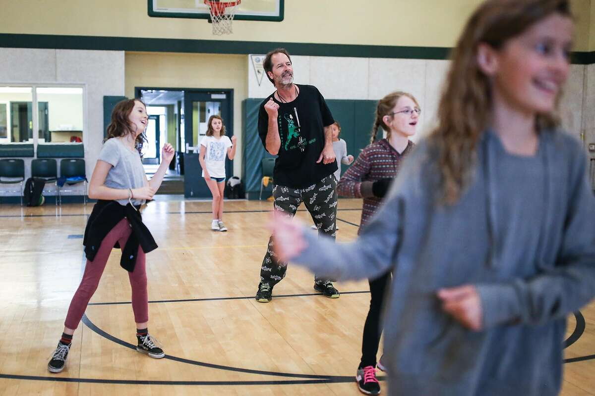 Buck Chavez, a PE teacher at San Geronimo Valley School, plays music and dances along with his students (left rot right) Eva Thomas, Beth Brisson, Kaitlyn Signor, and Grace Chavez (Buck's daughter) during a PE class on December 14, 2016 in San Geronimo, Calif.