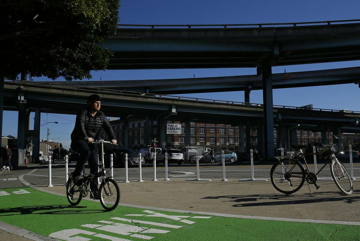 A bicyclist rides on new infrastructure at 9th Street and Division Street in this file photo from Wednesday, Dec. 21, 2016 in San Francisco, Calif. A bike sharing startup that had previously said it would dump bikes on the city's sidewalks changed its tune on Monday.