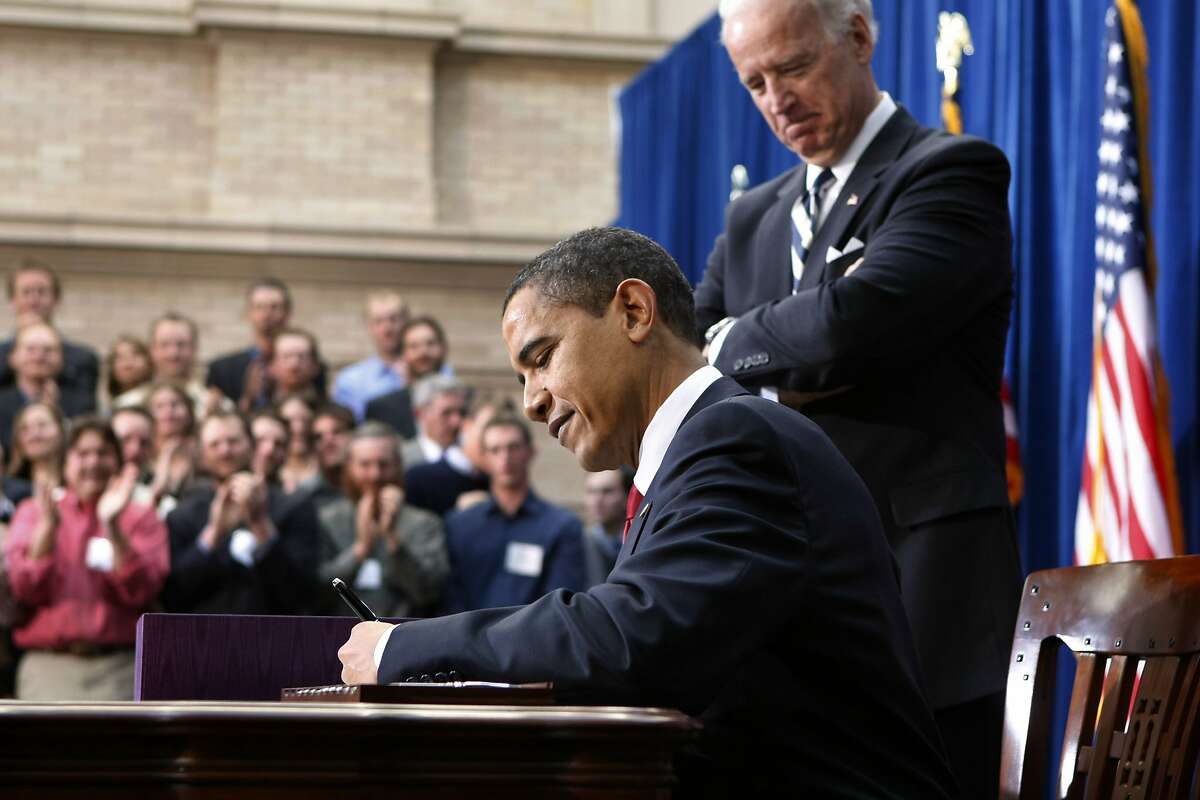 FILE - In this Feb. 17, 2009, file photo, Vice President Joe Biden watches as President Barack Obama signs the American Recovery and Reinvestment Act during a ceremony at the Denver Museum of Nature and Science in Denver. He was a first-term senator-turned-president. A former law professor with little experience in economics or management. When he walked into the White House he had one, clear job: Piece together the shards of a shattered U.S. economy. It wasn�t smooth and it wasn�t fast, but Obama ultimately succeeded. Obama will leave behind an economy far stronger than the one he inherited by most measures. (AP Photo/Gerald Herbert, File)