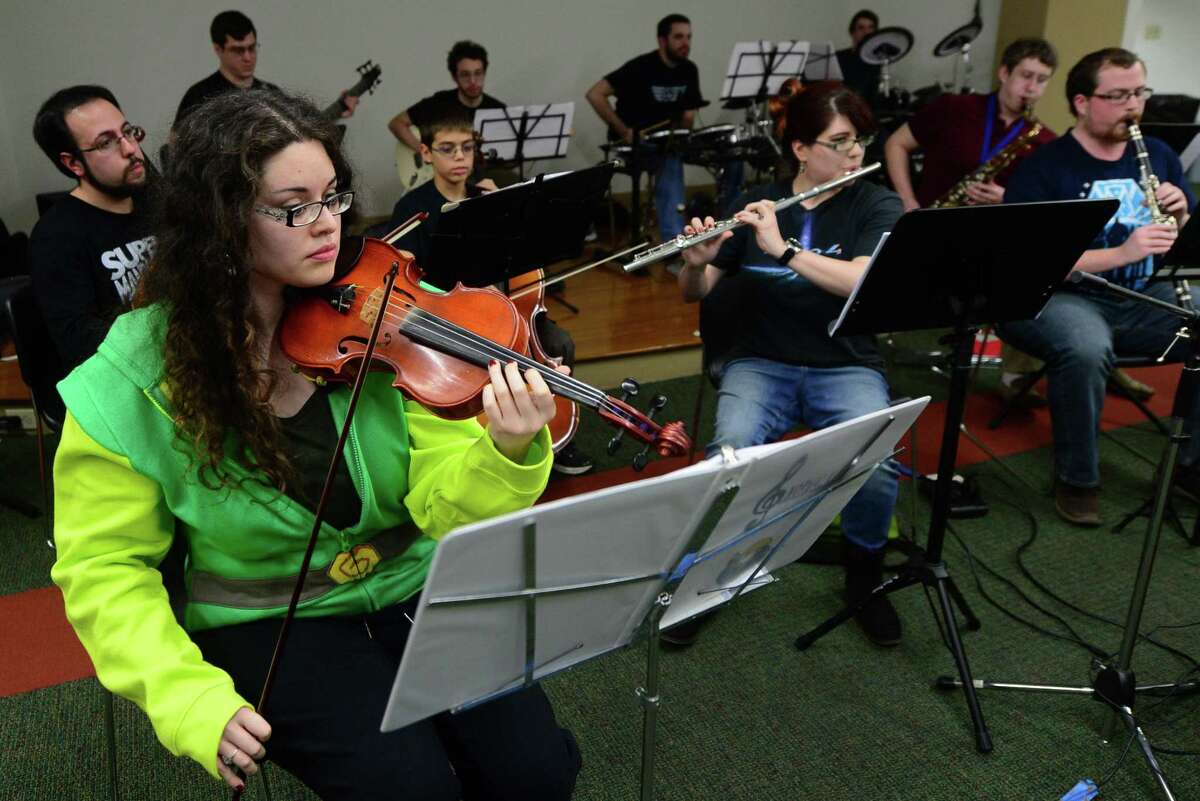 Cindy Reyes, left, and The National Gamers Symphony Orchestra (NGSO) play in their inaugural performance Saturday, December 3, 2016, at the South Norwalk Branch Library in Norwalk, Conn. NGSO was founded by Bryan Doyle, a former conductor for the University of Maryland's Gamer Symphony Orchestra. The small group of local musicians meet twice a month in an effort to improve as musicians, introduce the local community to the world of videogame music and promote musicianship. The group covered a few genres from the early days of video games to the modern: Starfox, The Legend of Zelda, and Journey.