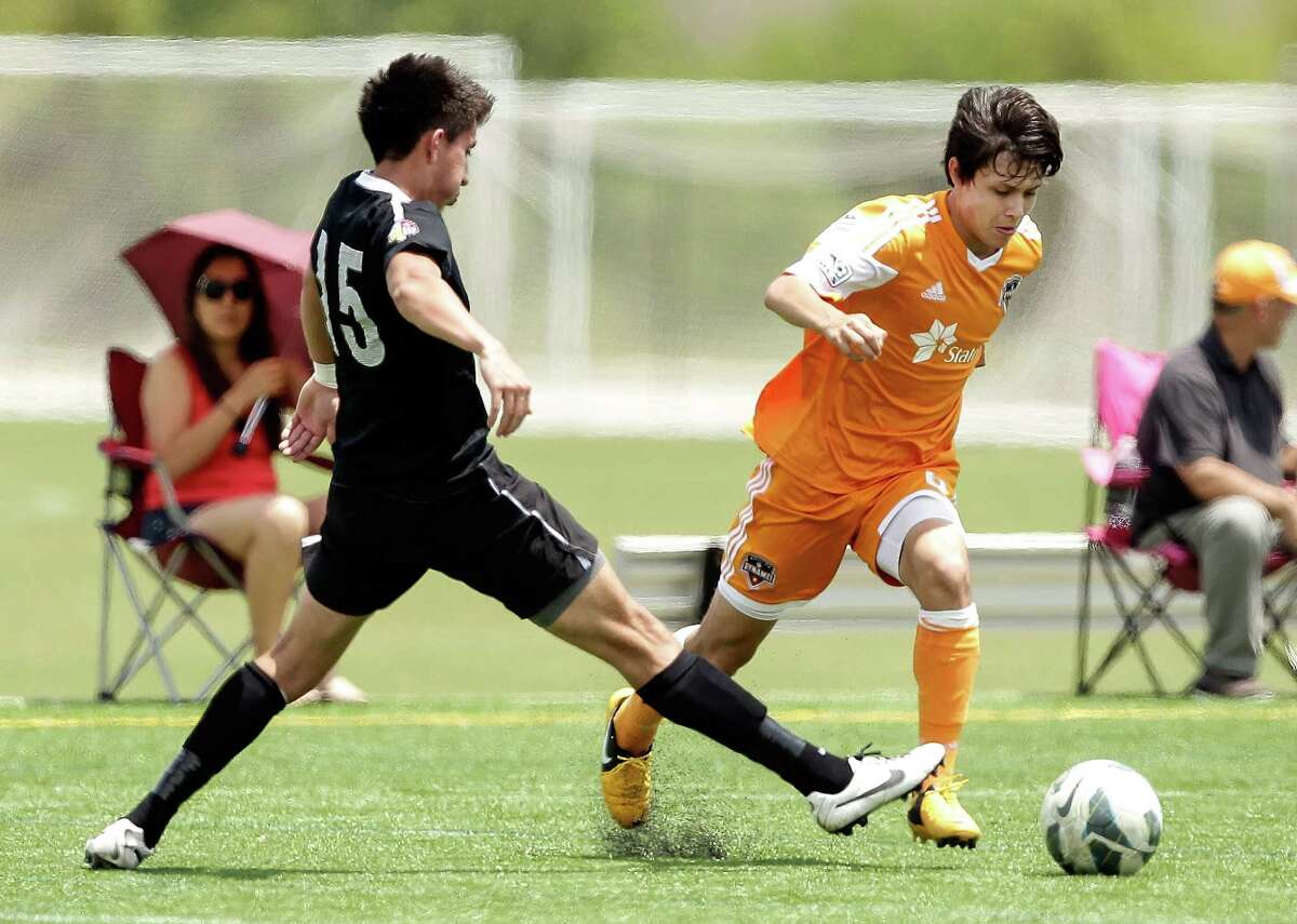 Houston's Christian Lucatero brings the ball up the field as Colorado's Mauricio Ovalle #15 as the Houston Dynamo Academy U16 team plays host to the Colorado Rush at the Houston Amateur Sports Park on Saturday, May 11, 2013.(Bob Levey/For The Chronicle)