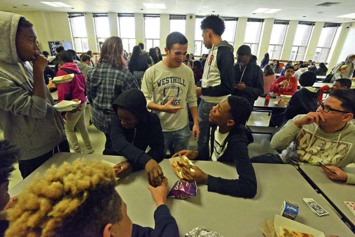 Noah Klein, Student Ombudsman for Westhill High School student newspaper Westword chats with students during lunch on Dec. 22, 2016. Klein and his fellow student journalists are leading the effort as the high school kicks off their Purple and Gold campaign, which aims to break the segregation stigma at the school's two cafeterias. For decades, the cafeterias have been informally referred to as "black caf" and "white caf," causing many students to sit with their race group.