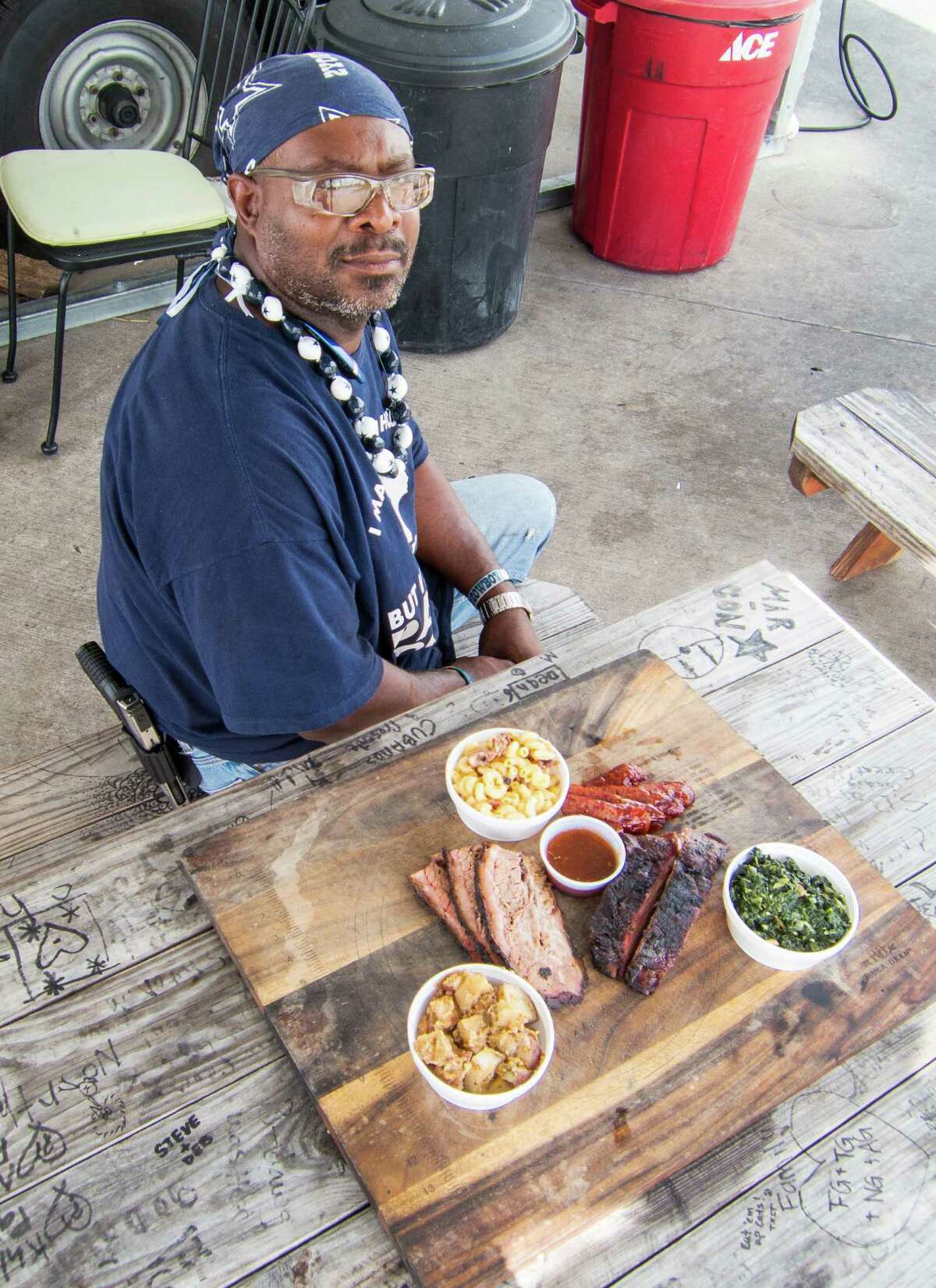 Trent Brooks with brisket, ribs, sausage and side dishes at Brooks' Place BBQ in Cypress.