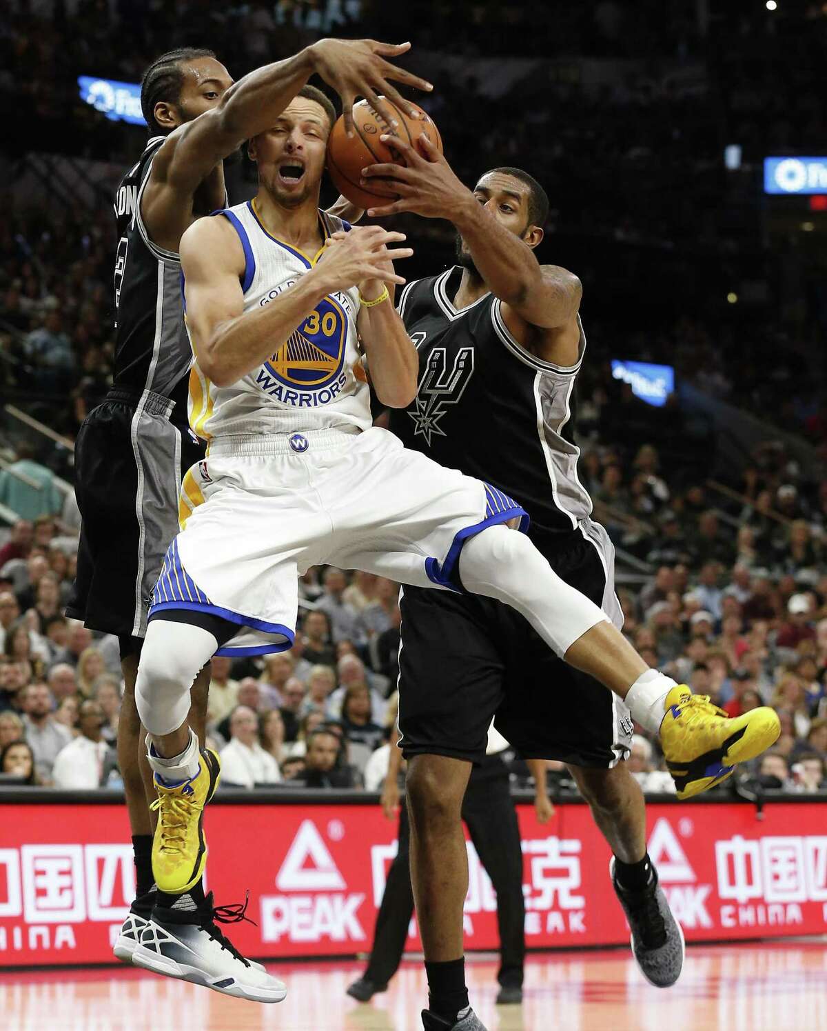 Spurs' Kawhi Leonard (02) and LaMarcus Aldridge (12) defend against Golden State Warriors' Stephen Curry (30) at the AT&T Center on Sunday, Apr. 10, 2016. The Warriors defeated the Spurs, 92-86. The Warriors with the victory also tied the 1995-96 Chicago Bulls for most wins in an NBA season with 72 victories. (Kin Man Hui/San Antonio Express-News)