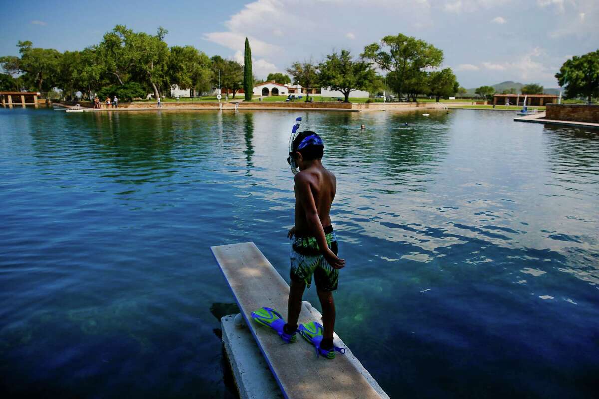 Dean Strong, 8, prepares to jump into the crystal clear waters of the worlds largest spring-fed swimming pool in his snorkeling gear at Balmorhea State Park Friday, Sept. 16, 2016 four miles west of Balmorhea in Toyahvale, TX. Houston-based Apache Corporation recently announced the discovery of an estimated 15 billion barrels of oil and gas in the area and plans to drill and use hydraulic fracturing on the 350,000 acres surrounding the park. Apache has leased the mineral rights under the park and town, but has promised not to drill on or under either. Even with the promises, some residents worry that the drilling could affect the 15 million gallons of water that flow through the pool every day and impact the more than 200,000 visitors the pool attracts annually. ( Michael Ciaglo / Houston Chronicle )