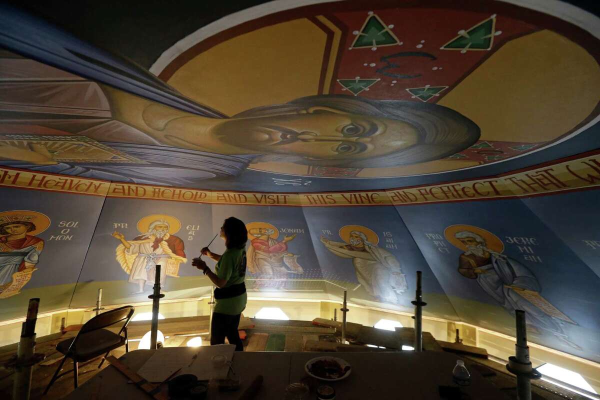 Artist Erin Kimmett puts the finishing touches on the icons on the dome of St. Anthony the Great.