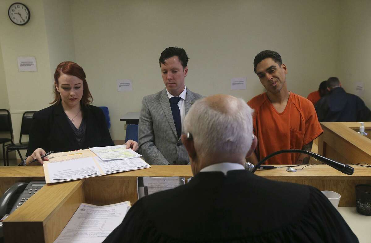 A defendant (right) appears Friday December 9, 2016 in jail court, also known as Auxiliary Court, at the Bexar County Jail. On the left is prosecutor Holly Lovett in the center is defense attorney Ryan Boyer and the judge (facing away) is Olin Strauss.