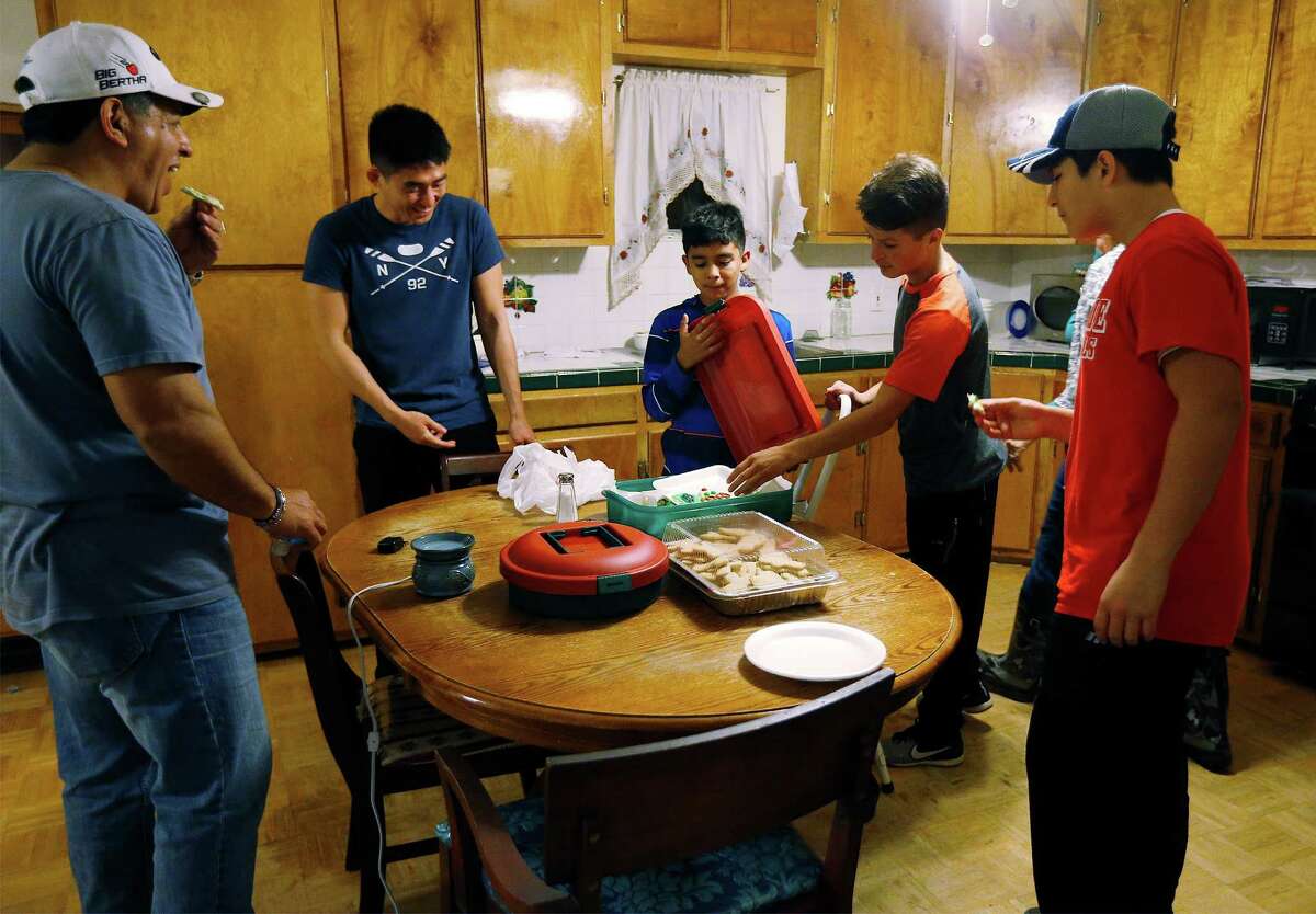 State Rep. John Lujan, left, eats Christmas cookies last week with his three adopted sons, Christopher, from right, Jesse and Michael - joined by Yao Chun-Wei, a former exchange student who stayed with Lujan and his wife, Freda.