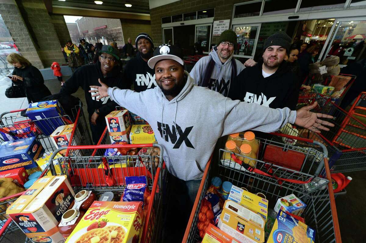 Local rapper FNX and his crew, from left, Mark Robinson, Anthony Grant, Marc Alan and Billy Gardella, finish shopping for food at Costco in Norwalk on Saturday to help feed several needy families using money raised through a GoFundMe campaign.