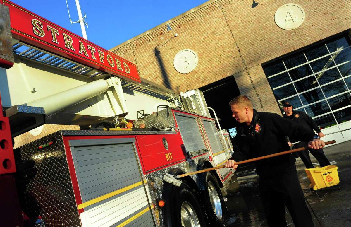 Firefighter Jimmy Becker washes a fire truck out in front of the Stratford Fire Department on Main Street in Stratford, Conn. on Tuesday Dec. 27, 2016. Fellow firefighter Jason "Jay" Carrafiello died suddenly at 38. Carrafiello, ?“was an outstanding firefighter and was held in high regard by all of the officers and firefighters,?’?’ Chief Robert McGrath said.