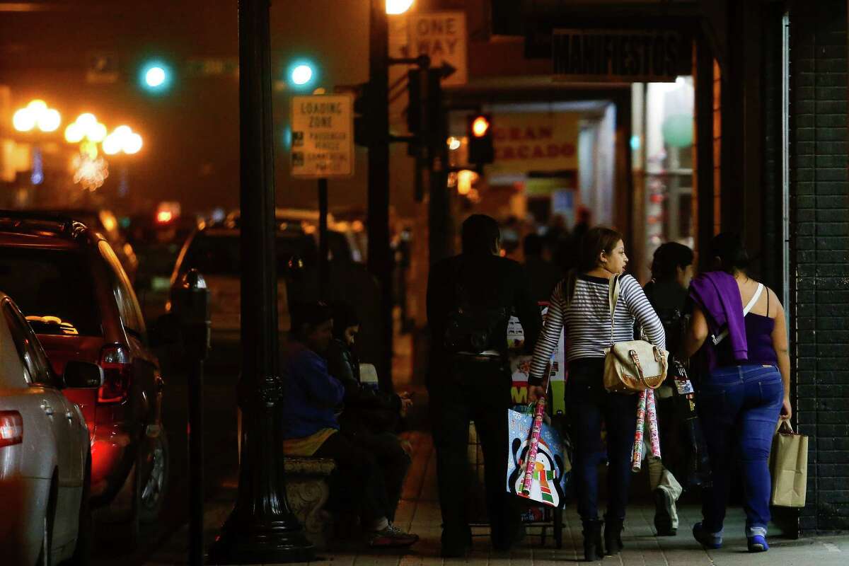 Shoppers walk back toward the border after shopping Thursday, Dec. 15, 2016 in Brownsville. Store owners in border towns such as Brownsville and McAllen are noticing a drop in sales as the peso declines in value against the US dollar. ( Michael Ciaglo / Houston Chronicle )