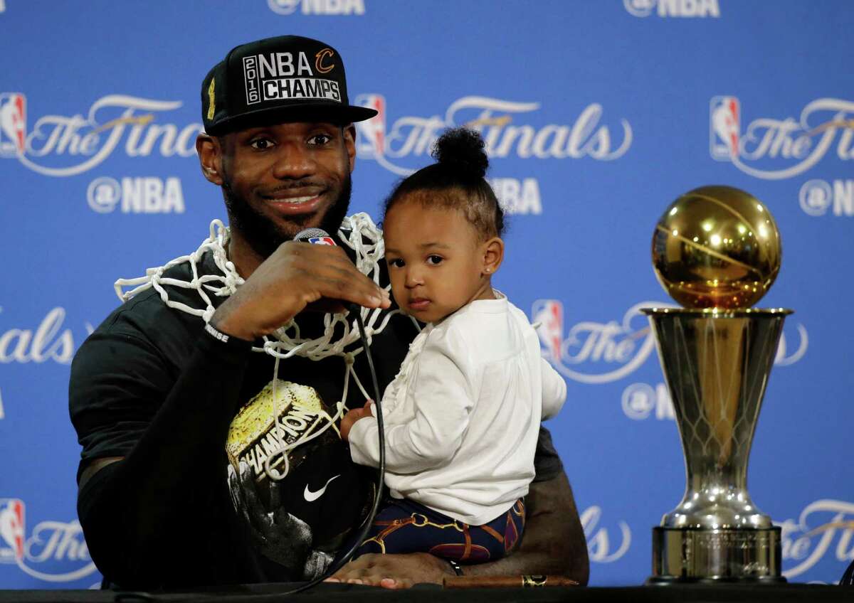 FILE - In this June 19, 2016 file photo, Cleveland Cavaliers' LeBron James answers questions as he holds his daughter Zhuri during a post-game press conference after Game 7 of basketball's NBA Finals Sunday, June 19, 2016, in Oakland, Calif. On Tuesday, Dec. 27, James, who ended 52 years of sports heartache by bringing Cleveland a championship and used his superstar platform to address social causes, was chosen as The Associated Press 2016 Male Athlete of the Year. (AP Photo/Eric Risberg, File, Pool)
